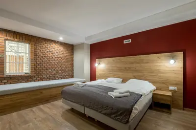 a bedroom with a bed and a brick wall at Hotel Vinnica in Wieliczka