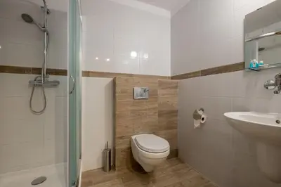 a bathroom with a toilet and a sink and a shower at Hotel Vinnica in Wieliczka