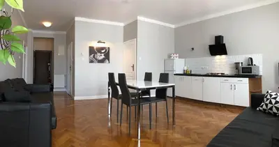 a kitchen and a living room with a table and chairs at Florianska Gate Luxury Apartments in Kraków