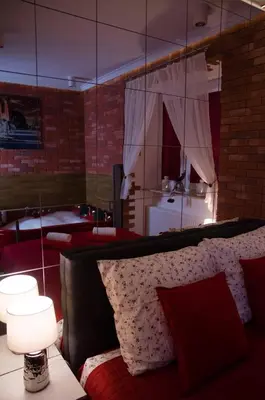 a living room with a couch and a mirror at Jacuzzi Apartment Red in Kraków