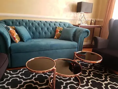 a living room with a blue couch and two tables at GoldStar Luxury Old Town Krakow Apartment in Kraków