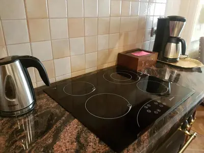 a black stove top with a coffee maker on it at GoldStar Luxury Old Town Krakow Apartment in Kraków