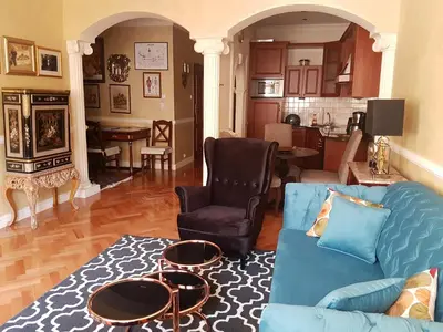a living room with a blue couch and a table at GoldStar Luxury Old Town Krakow Apartment in Kraków