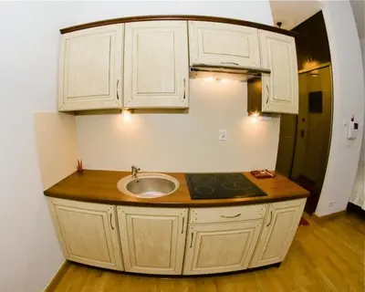 a kitchen with a sink and white cabinets at Apartament Kopernik in Kraków