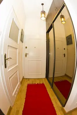 a hallway with a mirror and a red rug at Apartament Kopernik in Kraków