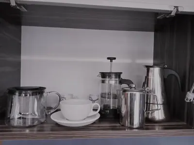 a shelf with pots and a cup and a coffeeucer at Apartament Jonek in Kraków