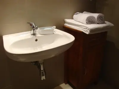 a white sink in a bathroom with a stack of towels at Apartament Jonek in Kraków