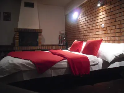 a bedroom with a large bed with red pillows at Apartament Berko in Kraków