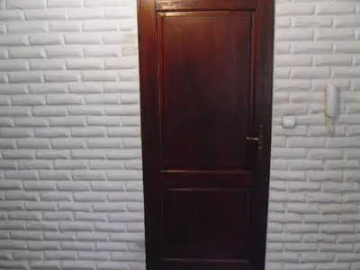 a wooden door in a room with a white wall at Apartament Berko in Kraków