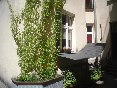a ivy covered building with a window and a porch at Apartament Berko in Kraków