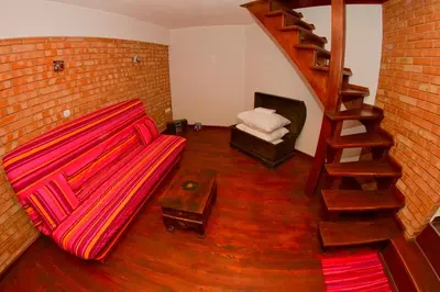 a living room with a red couch and a staircase at Apartament Berko in Kraków