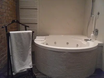 a bathroom with a large tub with a towel next to it at Apartament Berko in Kraków