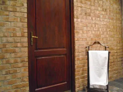 a wooden door with a towel hanging next to a brick wall at Apartament Berko in Kraków