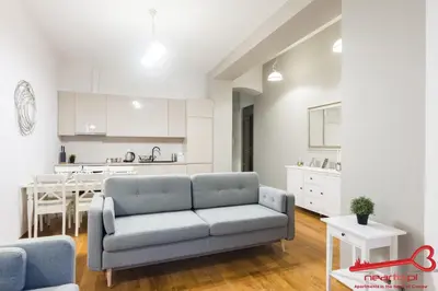 a living room with a couch and a kitchen at Apartment Old Town Topolowa in Kraków