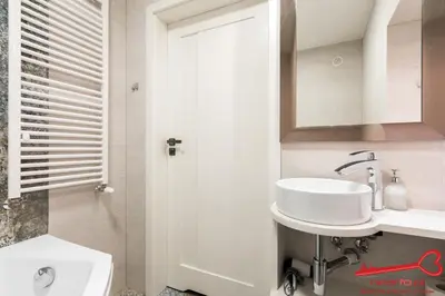 a white bathroom with a sink and a mirror at Apartment Old Town Topolowa in Kraków