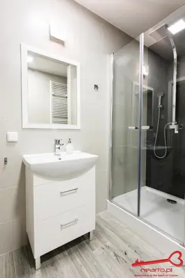 a white bathroom with a sink and a shower at Apartment Old Town Topolowa in Kraków