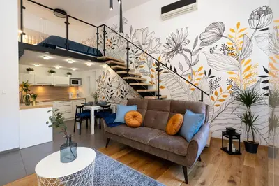 a living room with a couch and a staircase at Home Sweet Home in Kraków