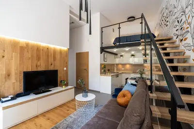 a living room with a couch and a tv and a staircase at Home Sweet Home in Kraków