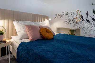a bedroom with a bed with a blue comforter and pillows at Home Sweet Home in Kraków