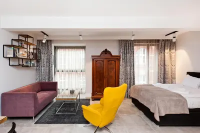 a bedroom with a bed and a yellow chair at Kazimierz Luxory, Sun & Snow in Kraków