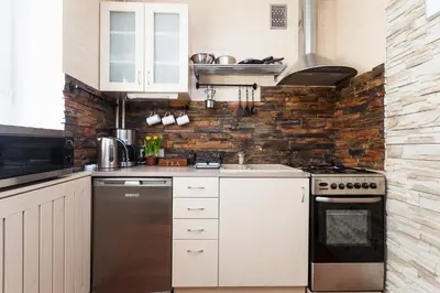 a kitchen with white appliances and a brick wall at Angel's studio - Jewish Quarter, Old Town (AirCon) in Kraków