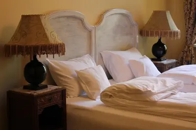 a bedroom with a bed with white pillows and two lamps at Cracow Apartments 24 in Kraków
