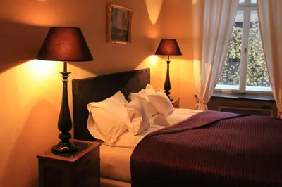 a bedroom with a bed with two lamps and a window at Cracow Apartments 24 in Kraków