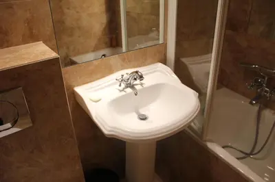 a bathroom with a white sink and a shower at Cracow Apartments 24 in Kraków