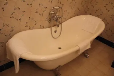 a white bath tub in a bathroom with a wall at Cracow Apartments 24 in Kraków