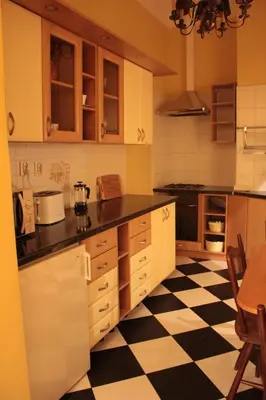 a kitchen with a black and white checkered floor at Cracow Apartments 24 in Kraków