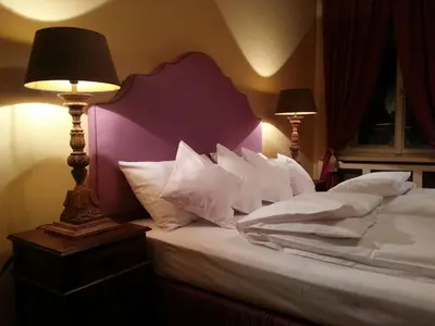 a bedroom with a bed with white pillows and a lamp at Cracow Apartments 24 in Kraków