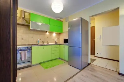 a kitchen with green cabinets and a blue refrigerator at Apartament 5 in Kraków