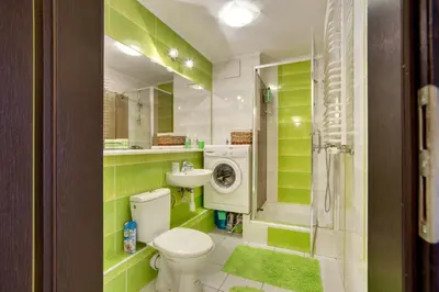 a green bathroom with a toilet and a sink at Apartament 5 in Kraków