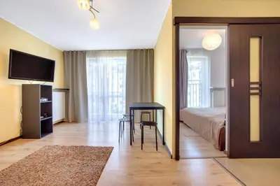 a bedroom with a bed and a table and a desk at Apartament 5 in Kraków
