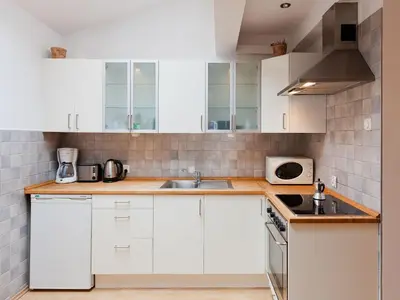 a kitchen with white cabinets and a sink at Studio Smart Apartment in Kraków