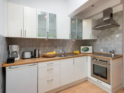 a kitchen with white cabinets and a sink at Studio Smart Apartment in Kraków
