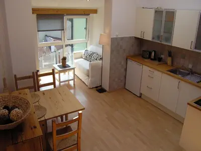 a kitchen and living room with a table and a couch at Studio Smart Apartment in Kraków
