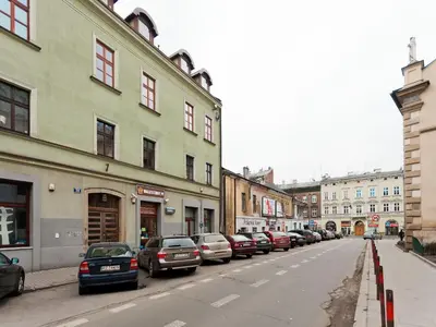 a row of cars parked on a street with buildings at Studio Smart Apartment in Kraków