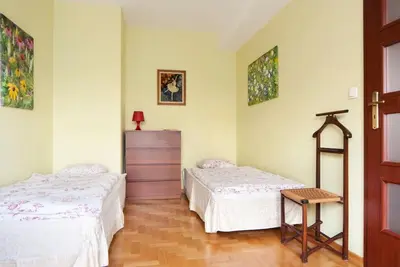 a room with two beds and a table in it at Trinity Apartment in Kraków