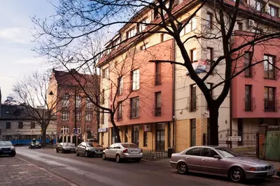 a city street with cars parked in front of buildings at Trinity Apartment in Kraków