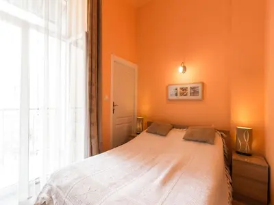 a bedroom with a bed with an orange wall at Old Town Apartment in Kraków