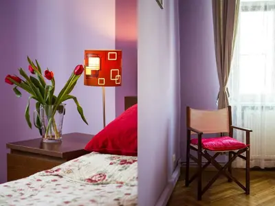a bedroom with a vase of flowers and a chair at Old Town Apartment in Kraków