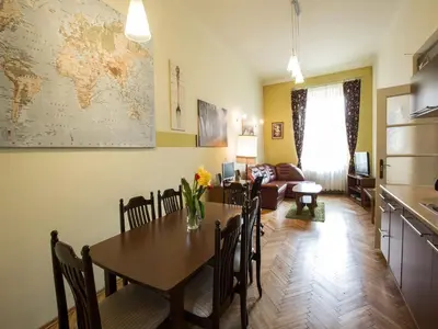 a kitchen and dining room with a table and a living room at Old Town Apartment in Kraków