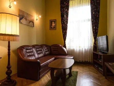 a living room with a leather couch and a television at Old Town Apartment in Kraków
