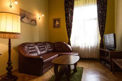 a living room with a leather couch and a television at Old Town Apartment in Kraków