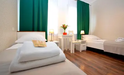 a hotel room with two beds and green curtains at Cracow Central Aparthotel in Kraków