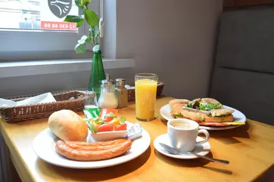 a table with two plates of breakfast foods and drinks at Cracow Central Aparthotel in Kraków