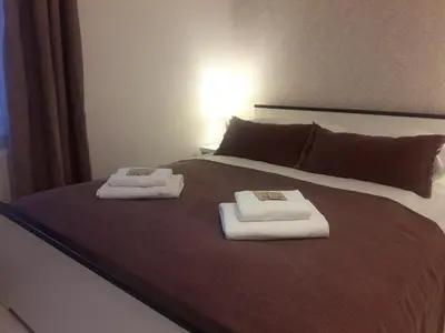 a bed with two towels on top of it at Cracow Central Aparthotel in Kraków