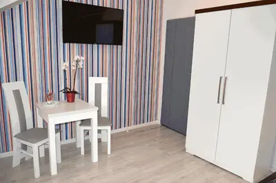 a dining room with a table and a white cabinet at Cracow Central Aparthotel in Kraków