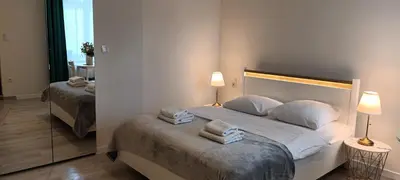 a bedroom with a bed with two pillows and a mirror at Cracow Central Aparthotel in Kraków